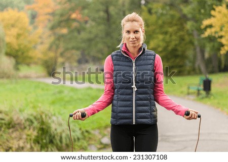 Young attractive woman jumping rope in park