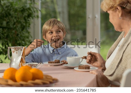 Boy eating tasty cake made by his granny