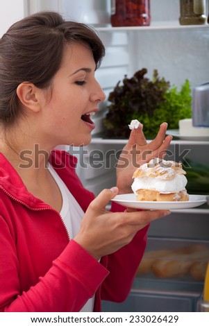 Young pretty woman tasting delicious cake with whipped cream