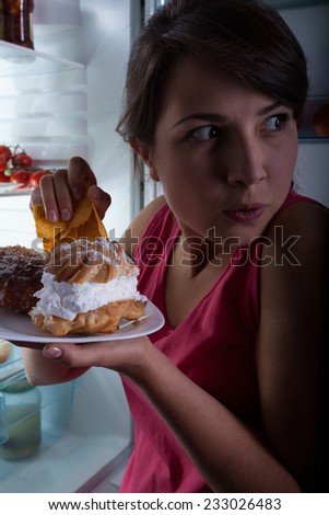 Young beautiful woman eating cakes in secret