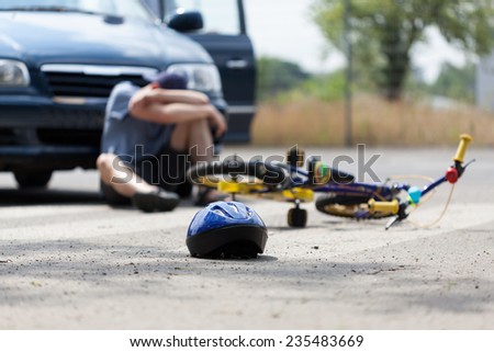 A boy suffering after a bike accident with a car