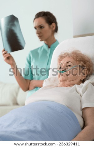 Young pretty doctor diagnosing the sick older woman