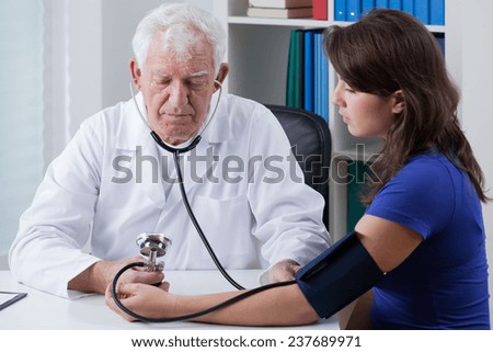 Young woman in doctor\'s office and her pressure measurement