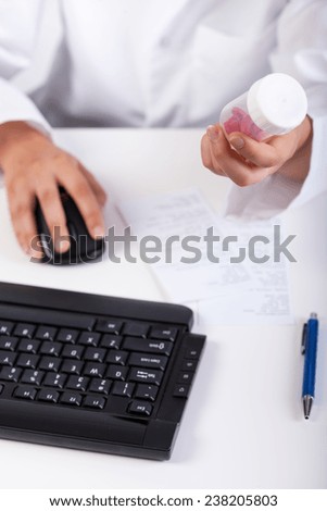 Pharmacist using computer during work in pharmacy