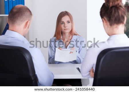 Worried girl shows her CV on a job interview