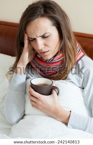 Lying woman in scarf having high fever