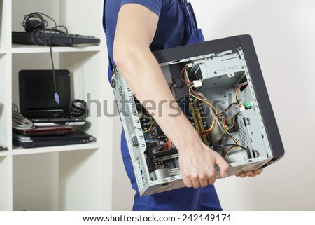 Young strong mechanic carrying dismalted computer
