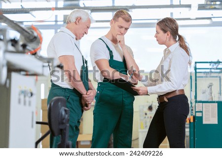 Angry manager controlling employees in manufacturing plant