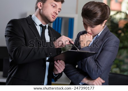 Strict boss talking with his young secretary