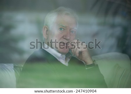 Elegant elder man sitting on the couch
