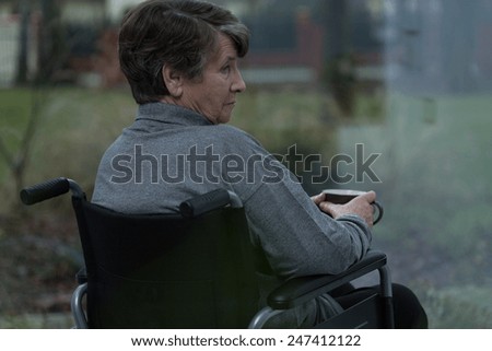 Older injured depressed woman relaxing with cup of tea