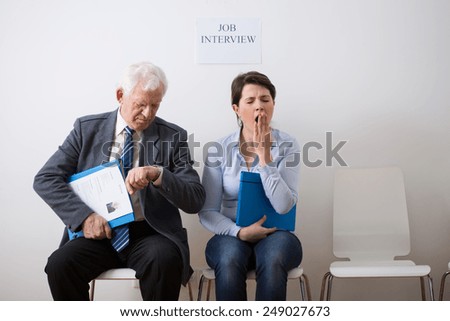Two bored candidates waiting for job interview