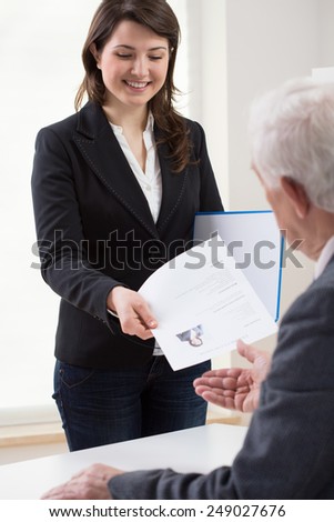 Young smiling woman presenting curriculum vitae on job interview