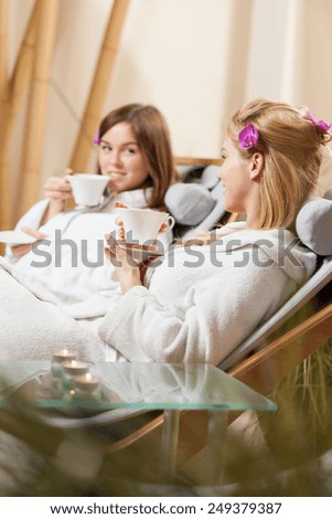 Lady friends drinking tea at spa room
