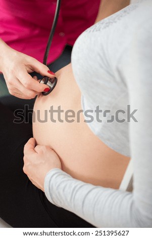 Close-up of obstetrician auscultating the fetus