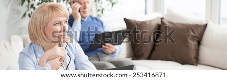 Panoramic photo of busy aged businesswoman at home