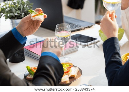 Close-up of young businessman eating his sandwiches for lunch