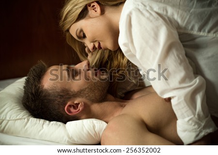 Young attractive couple in love hugging in bed