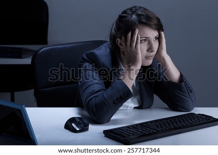 Horizontal view of tired businesswoman working overtime