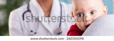 Baby boy in mom\'s arms at doctor\'s office
