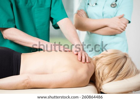 Woman lying on treatment couch having medical massage