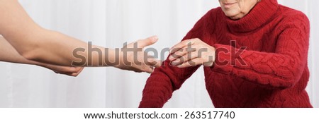 Elderly woman trying to walk on crutches