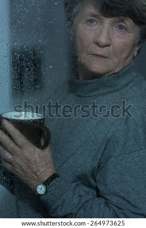 Retired woman having bad mood in rainy day
