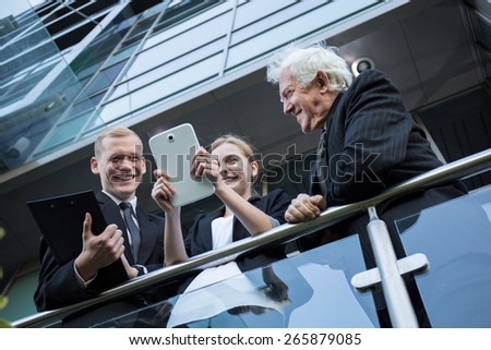 Happy workers using tablet during a break