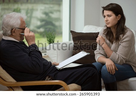 Young woman talking with her older psychologist