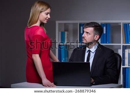 Young seductive secretary working late at office with her boss