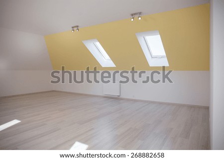 Spacious room in the attic with sloped ceiling