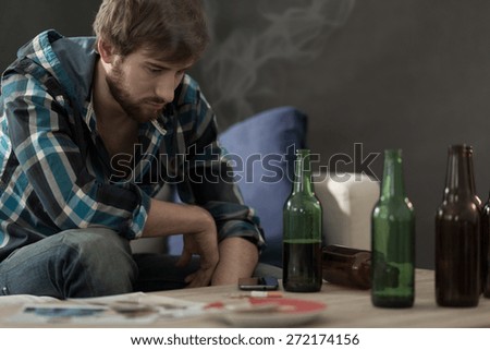 Picture of young alcoholic drinking beers alone