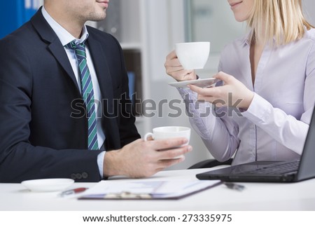 Office workers sitting at the table and drinking coffee