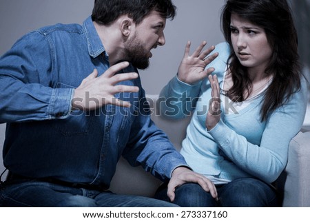 Angry aggressive husband trying to hit his wife