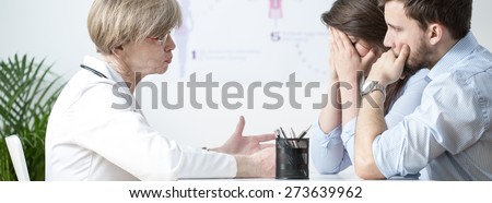 Young infertile woman crying at doctor\'s office