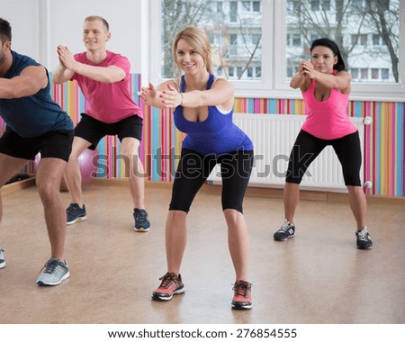Gym people doing squats during fitness classes