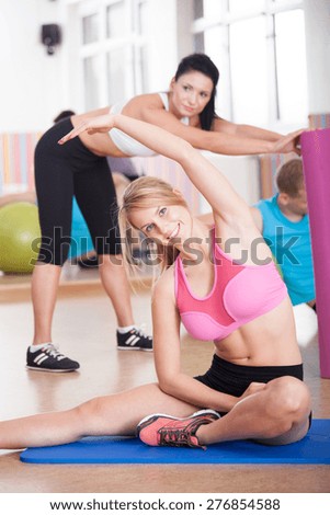 Image of fit people stretching at the gym