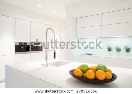 Fruit in a bowl on the marble island in white kitchen
