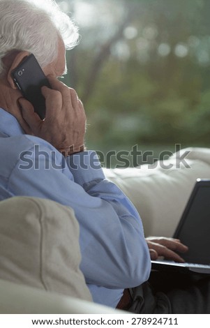 Vertical view of senior businessman using technology