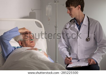 Sick older man with headache complaining to his physician