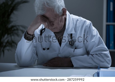 Older sick exhausted doctor with deep depression
