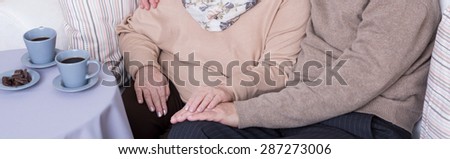 Close-up of wife touching her husband\'s hand