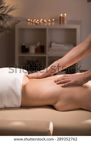 Photo of young woman having sensual massage in spa