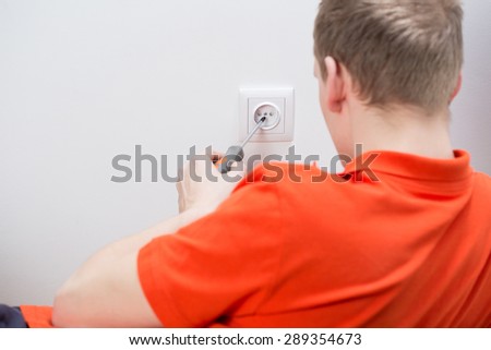 Man during repairing electrical socket at home