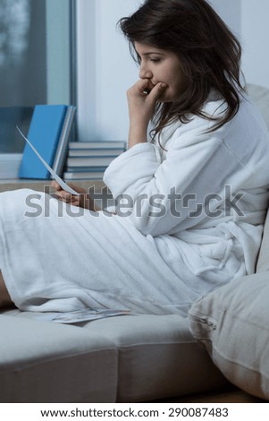 Picture of thoughtful sad woman sitting on the couch