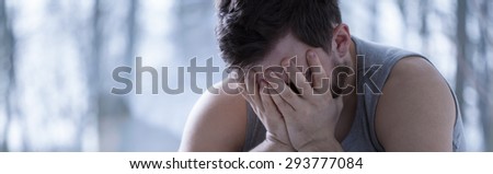 Depressed man suffering from insomnia covers his face