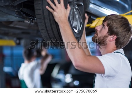 Close-up of automobile mechanics repairing a car