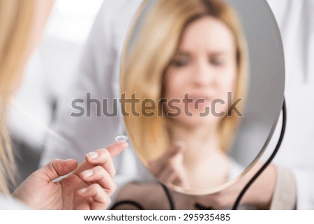Young woman using first time contact lenses