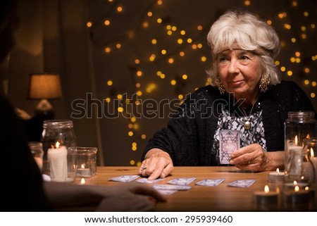 Photo of smiling elder female telling someones fortune