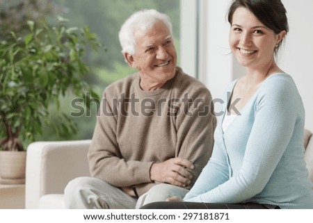 Smiling grandpa and caring granddaughter at home